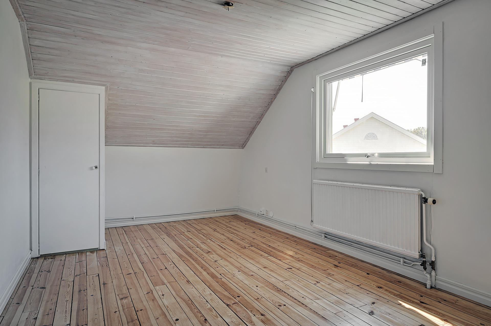Ett större sovrum med gavelfönster åt väster