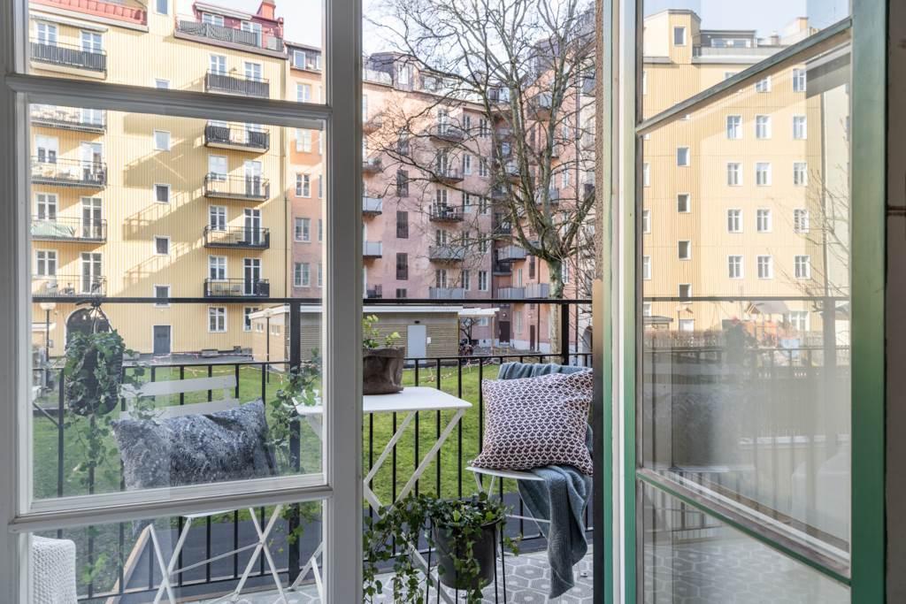 Lågupplöst Stor smidesbalkong mot en härlig och öppen gård